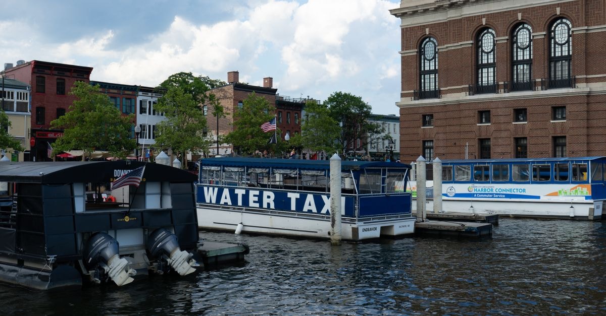 Water taxis and historic architecture at Baltimore Harbor waterfront.