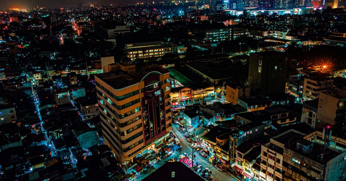Hotel Sogo Avenida in Manila: A Rizal Avenue Stay on Dimson Building's 6th Floor A bustling cityscape captured at night showcasing illuminated buildings and streets from an aerial perspective.