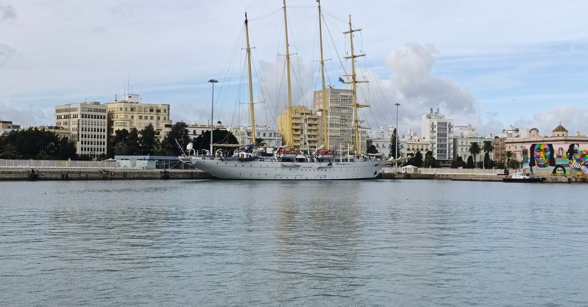 Port of Spain Travel Guide: Getting Around and Catching the Vibe Sailing ship docked in Cádiz harbor with cityscape and clear skies.