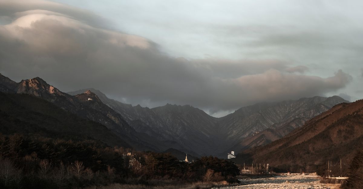 Kanggye Travel Guide: Into Chagang’s Remote Mountain City Majestic mountain range with dramatic clouds forming overhead, capturing nature's beauty.