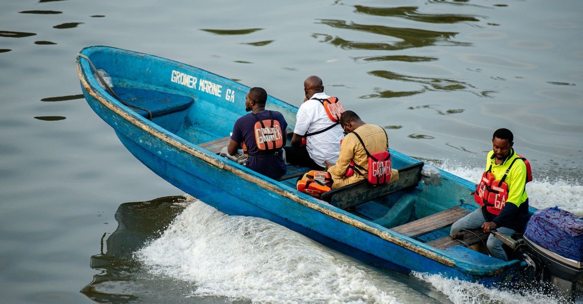 Ebute Ikorodu Travel Guide: Lagos's Quiet Lagoon Edge Group of men in a blue motorboat navigating the waters of Lagos, Nigeria.
